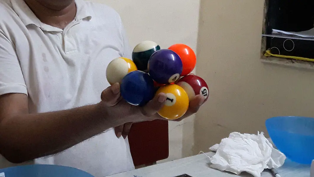 Challenge: Can you beat this record for the most pool balls held in one hand?