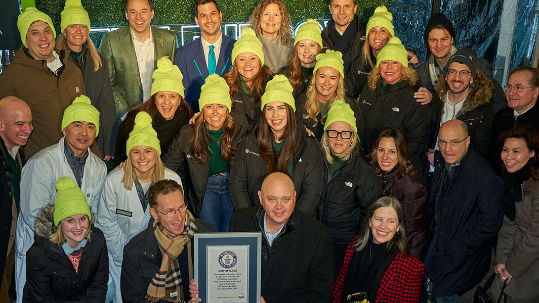 split image of a man standing next to a guinness world records adjudicator and a team photo of ge veronva employees