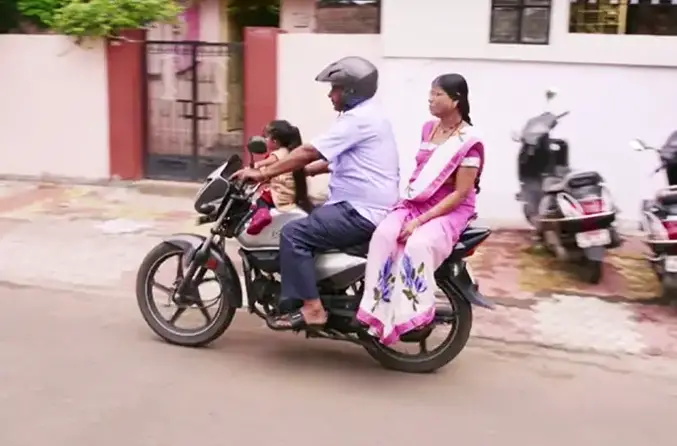 Jyoti riding motorcycle with her parents