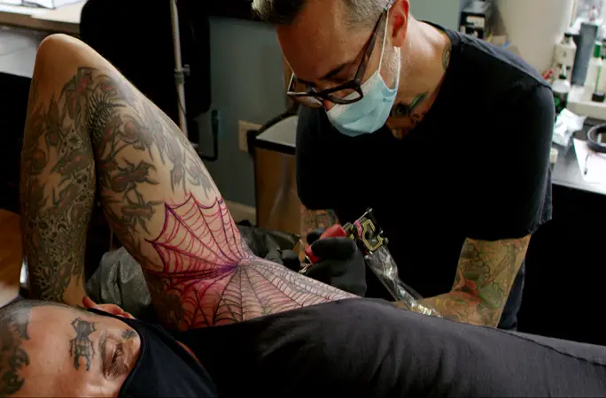 Mike getting new spiderweb tattoo