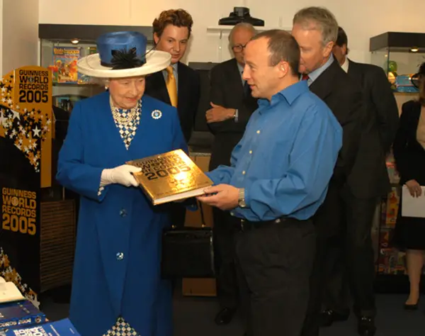 Queen Elizabeth II being given a Guinness World Records book by GWR President Alistair Richards