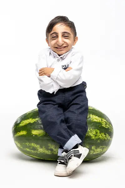 Worlds shortest man sitting on a watermelon