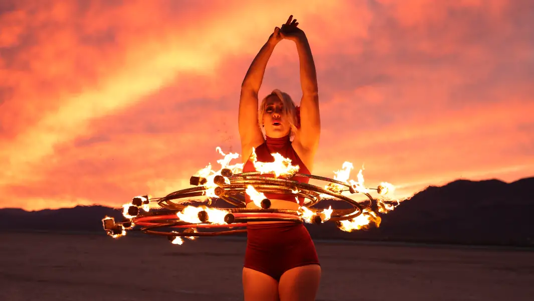 Fire performer fights through 'fire kiss' burns to spin eight flaming hula hoops