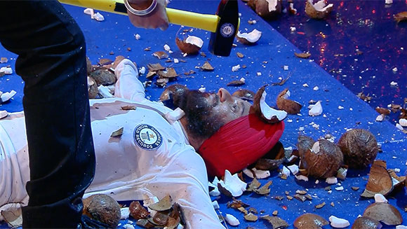 Most coconuts smashed around a person while blindfolded in one minute header