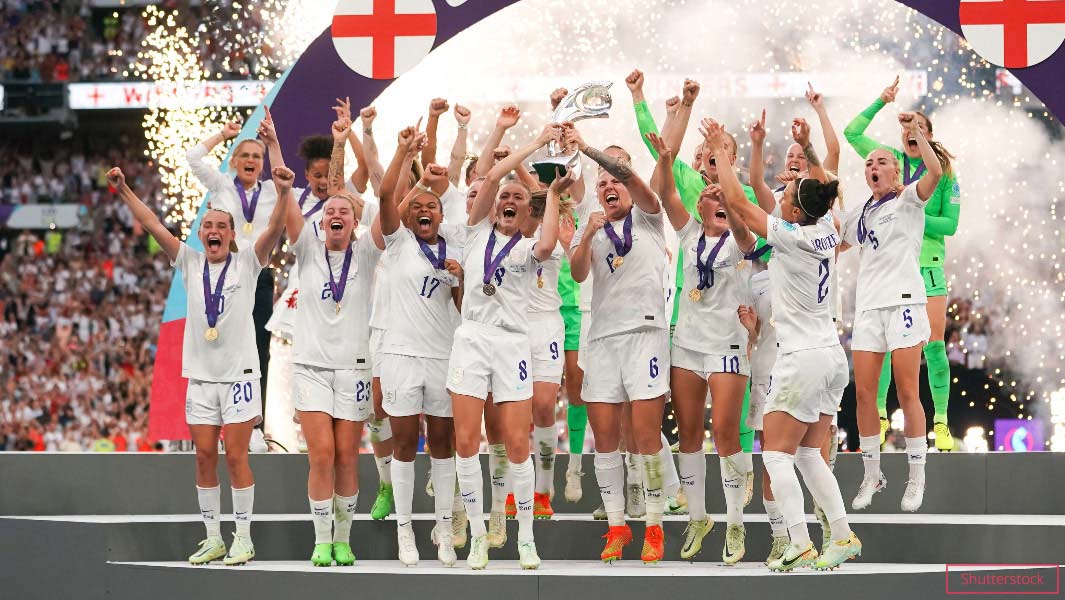 england women celebrating winning the UEFA womens Euro 2022 on platform holding trophy