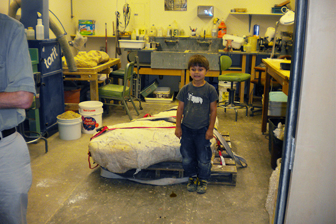 wylie-brys-standing-in-front-of-dinosaur-fossils.jpg