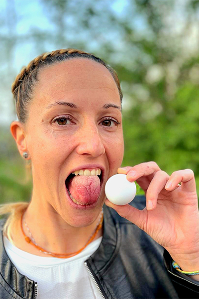 Ambra holding a ping pong ball next to her tongue