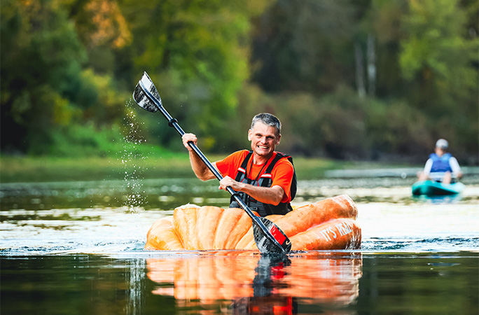 Gary smiling while paddling in his pumpkin
