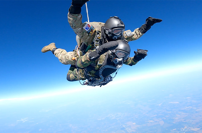 Alex and Jim with their hands up in the air during their skydive