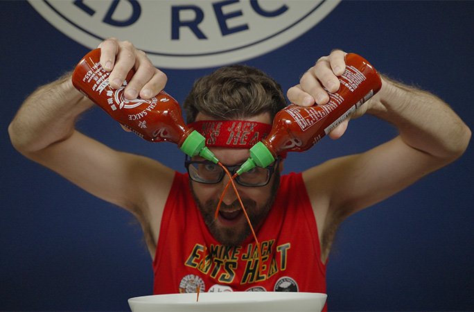 Mike pouring hot sauce into a bowl