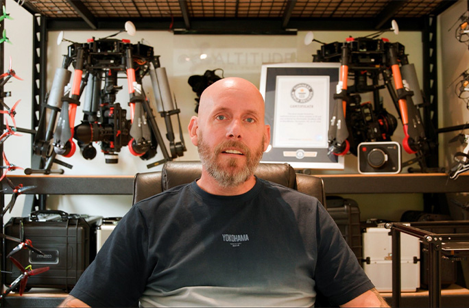 Chris with his certificate and drones behind him