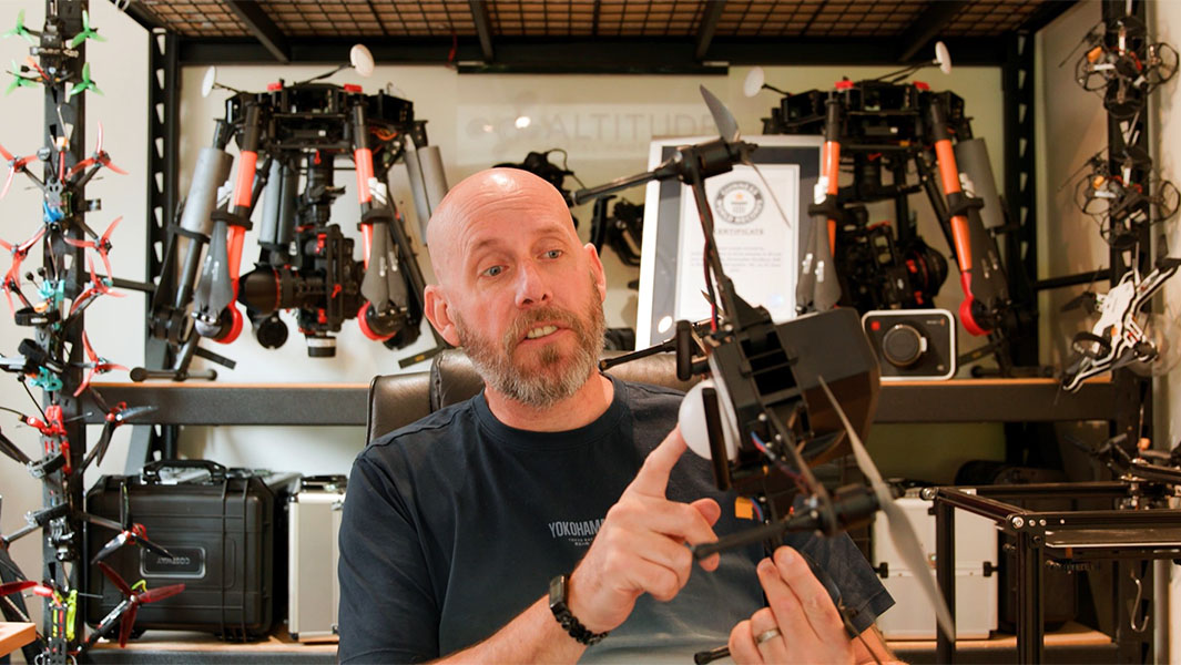 Split image of Christopher Bradbury holding a drone and an emoji formed by drones