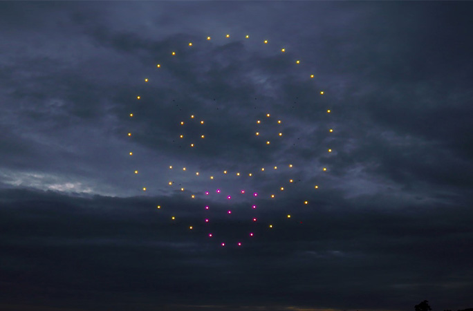 Smiley face emoji with tongue sticking out formed by drones