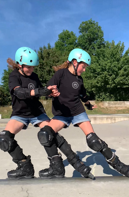The twins skating together at the park