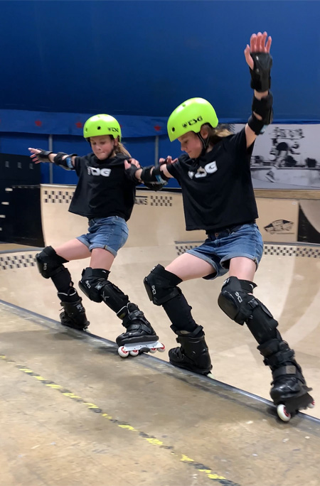 The twins grinding on the edge of a halfpipe