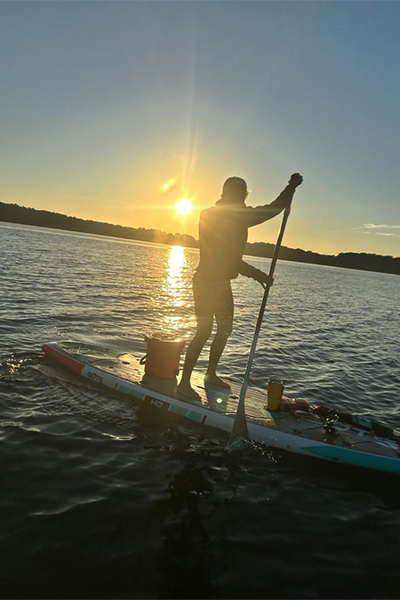 Bonnie paddleboarding at sunset