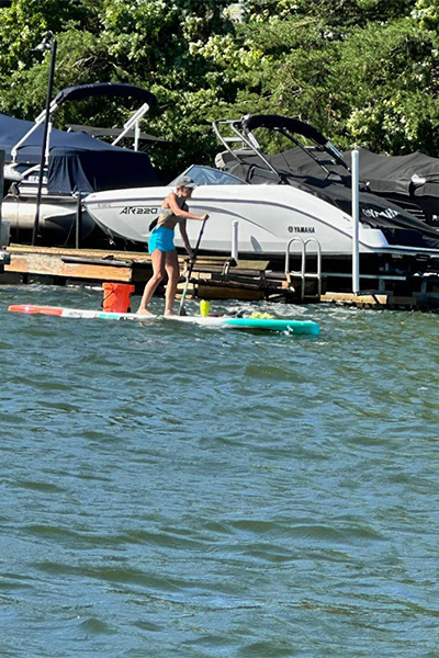 Bonnie paddleboarding past some yachts