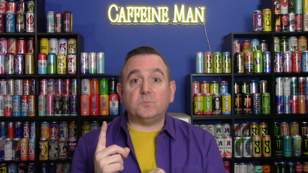 Close up of CaffeineMan standing in front of energy drinks cans