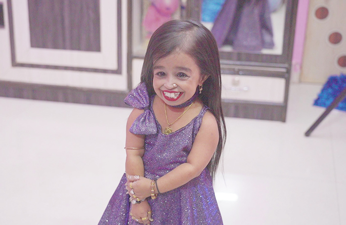 Jyoti smiling in a purple dress