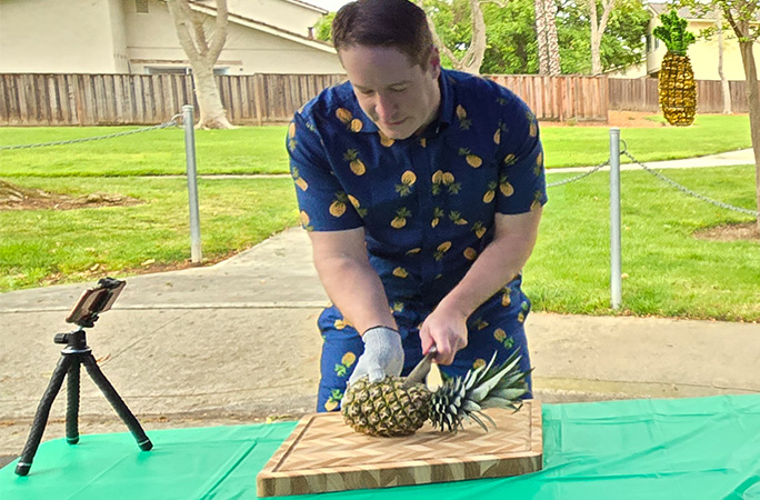 Rich cutting a pineapple