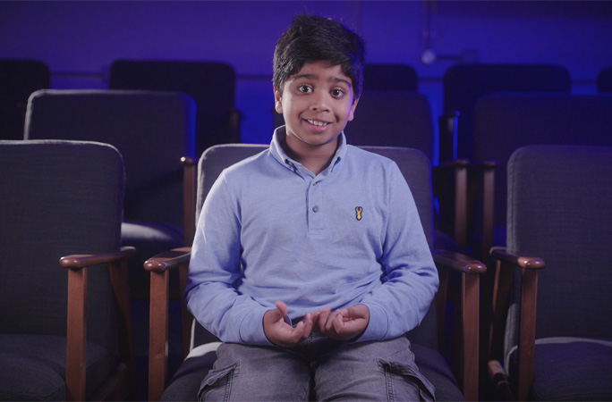 Aneeshwar sitting in a chair