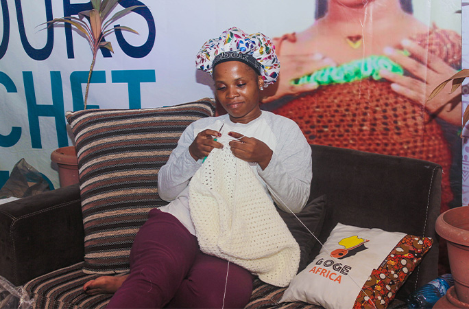 Chidinma smiling while crocheting