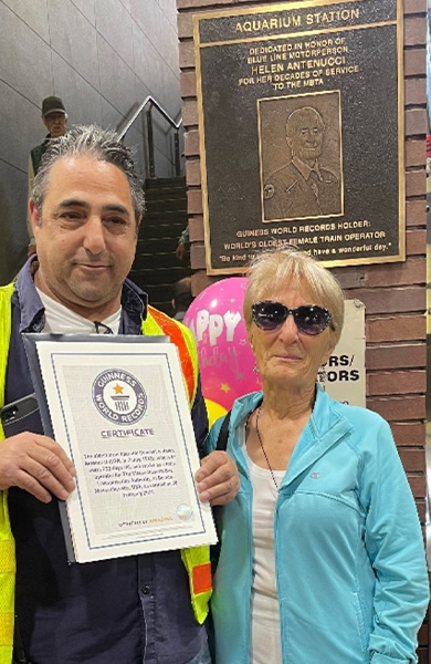 Helen standing at Aquarium station in front of plaque