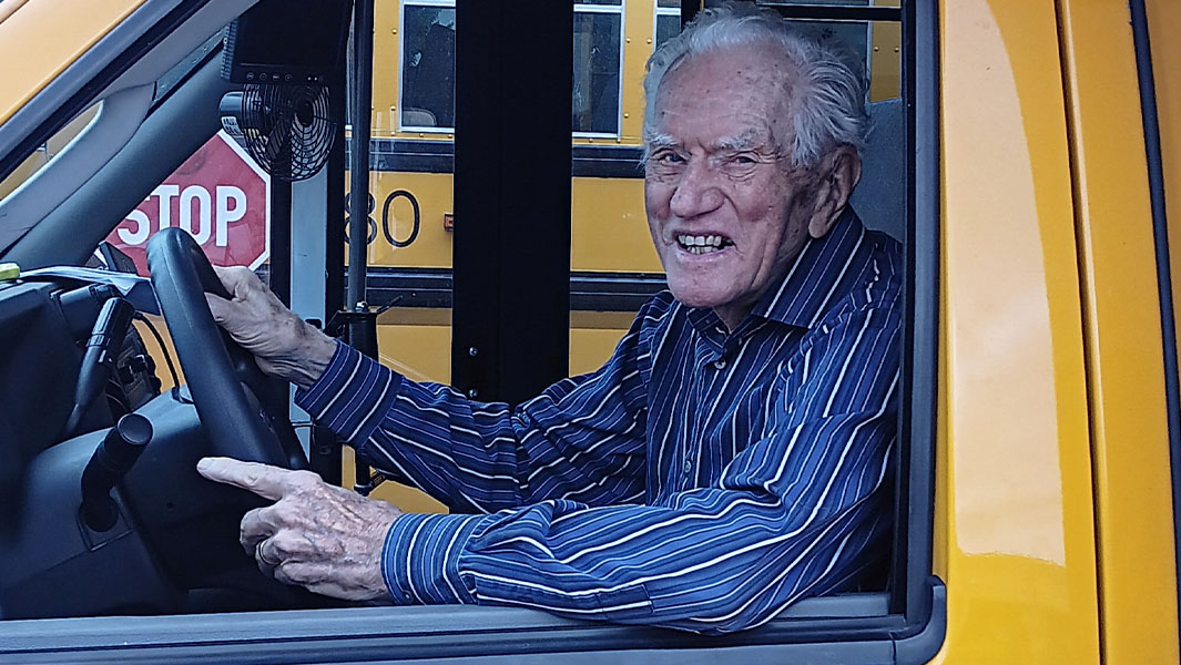 James Oppegard smiling while sitting in school bus