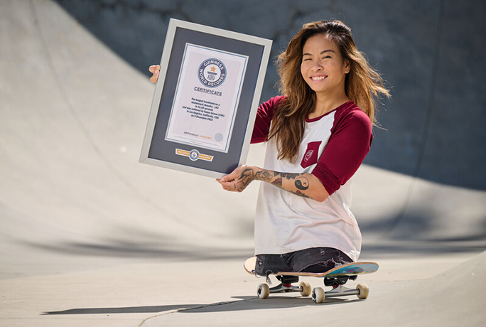 Kanya and certificate on a skateboard smiling
