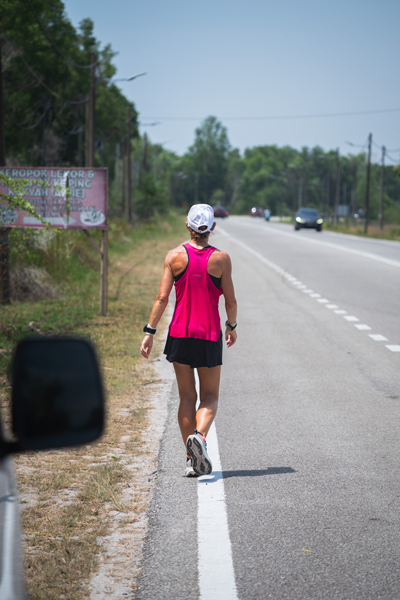 Natalie Dau on the road, facing her back