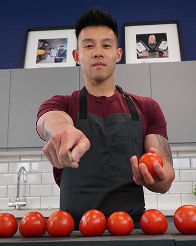Wallace Wong holding a tomato and knife