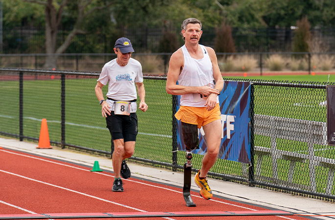 Adam tapping his watch while running