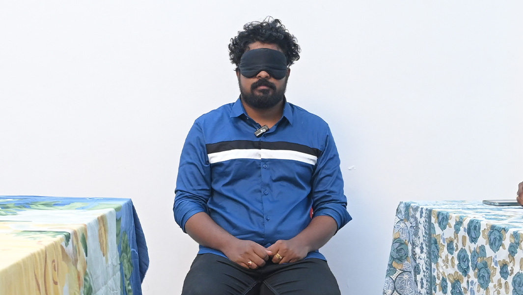 Deepu blindfolded sitting on a chair