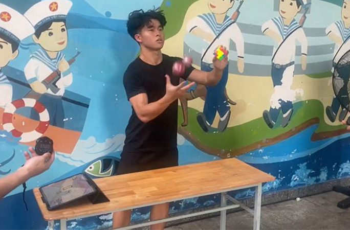 Daryl juggling and solving a puzzle cube