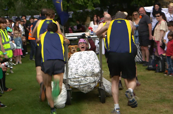 People running while holding a bed
