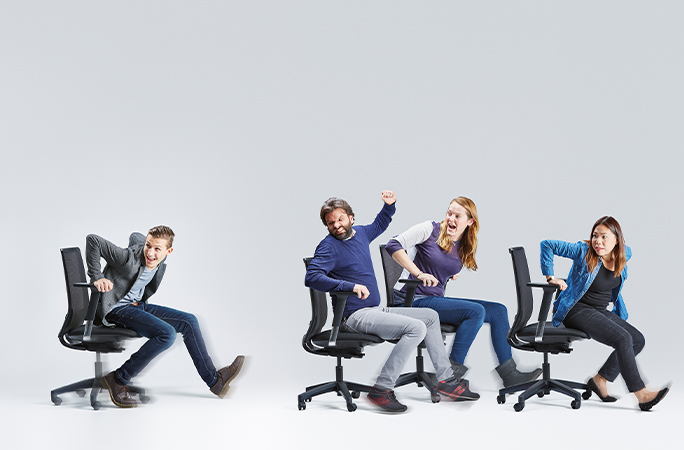 People running while pushing someone in an office chair