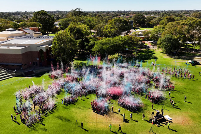 People launching colourful confetti aerial view