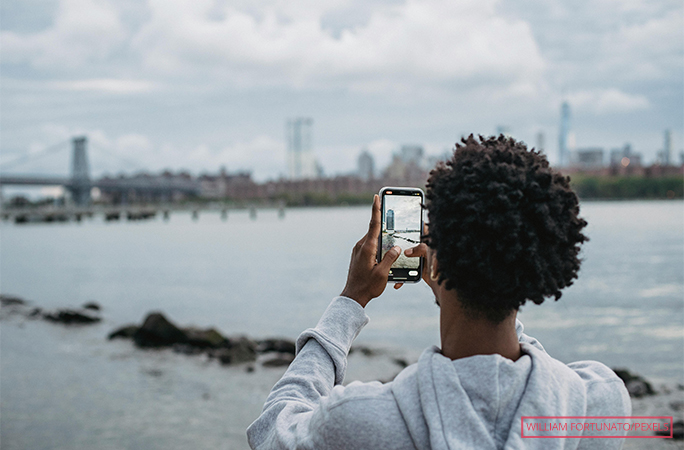 A man taking a photo of a bridge in New York