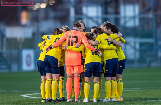 A women's soccer team huddled together