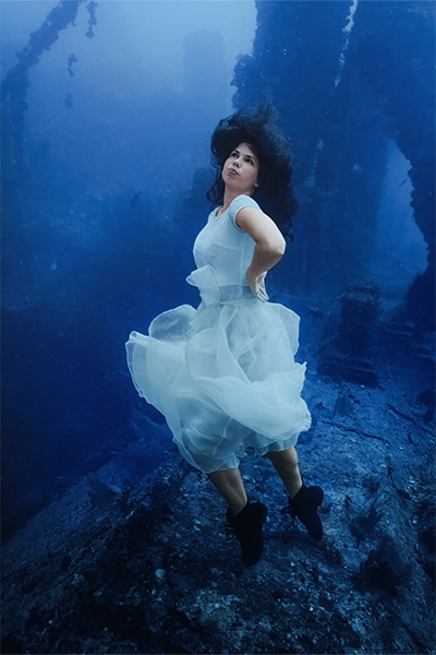 Model posing underwater with her hands on her hips