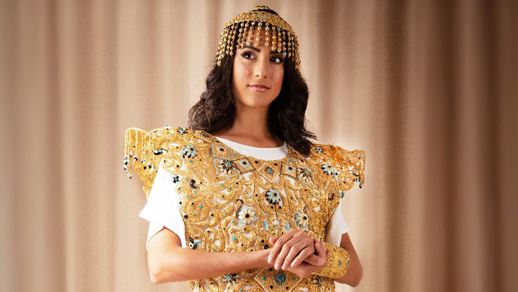 a woman wearing an ornate gold dress and jewelled headdress.