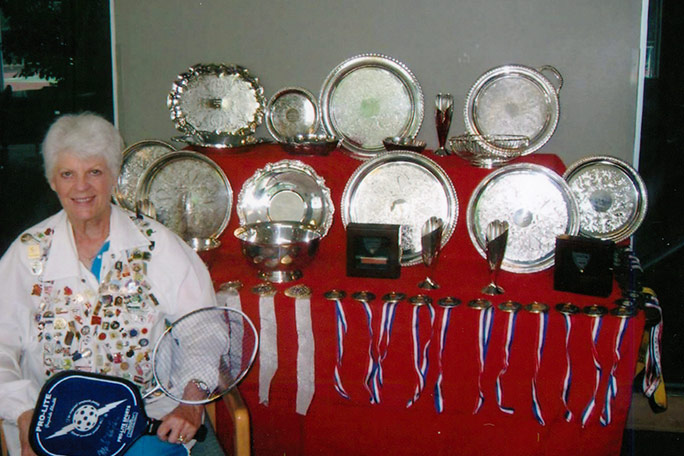 joyce-jones-with-trophies-and-medals-for-badminton-and-pickleball