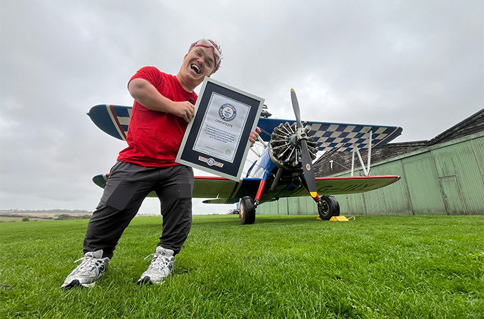 John in front of the plane with his certificate