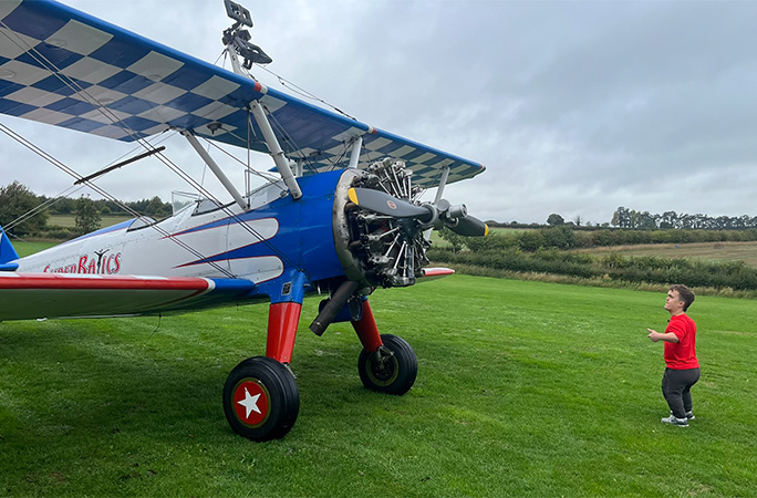 John standing in front of the plane looking up at it