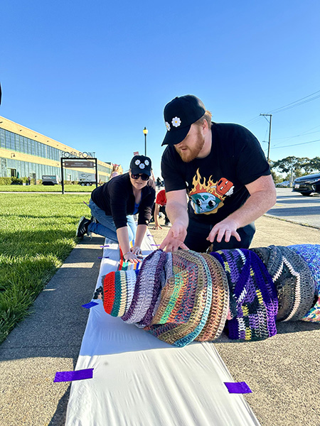 Two volunteers measuring the scarf