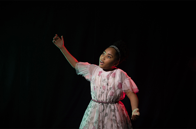 Victory holding her arms up while singing