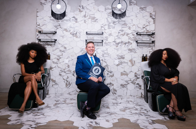 Aevin and Jess sitting with Michael on salon chairs