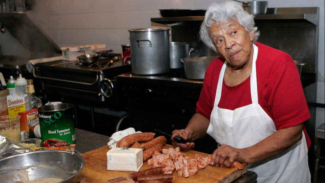 Leah Chase cutting sausage