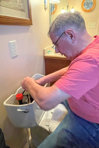 Ross repairing a toilet