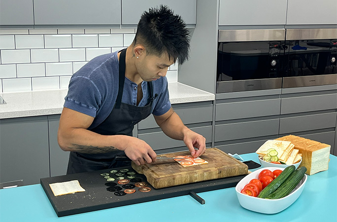 Wallace adding ingredients to the sandwich